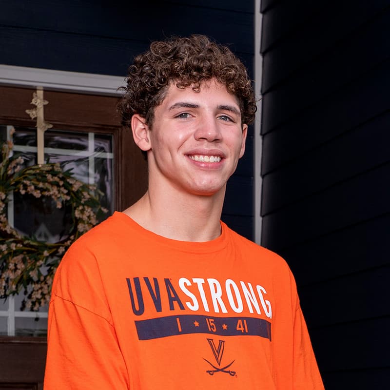 Chase Archer, Reynolds ACA alumni, poses in orange UVA shirt