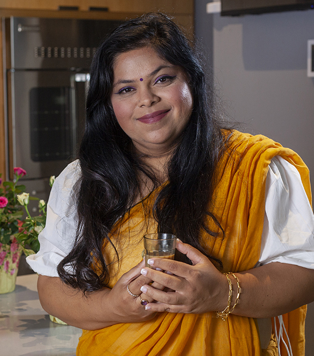 Indian woman, Keya Wingfield poses in Indian dress in industrial kitchen