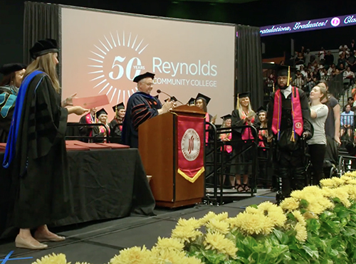 Graduating student walks on stage in exoskeleton to receive diploma