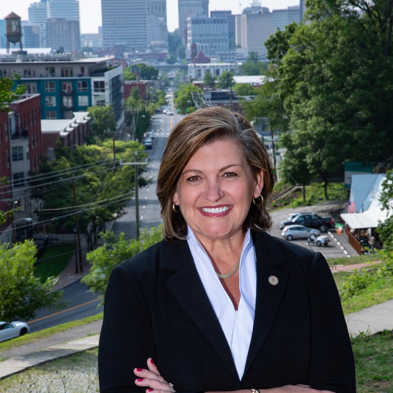 Reynolds Community College President Dr. Paula Pando stands with arms crossed with the city of Richmond behind her.