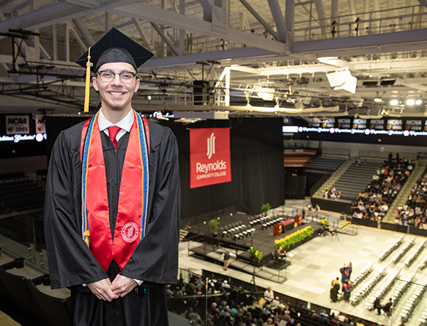 Sebastian Portillo, student graduation speaker, Spring 2025, stands above the commencement stage