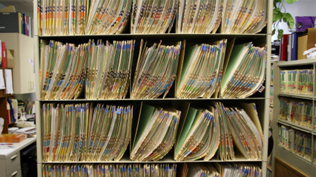 A tall stack of files neatly organized on a shelf.