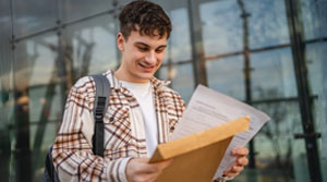 Student grinning and looking at papers